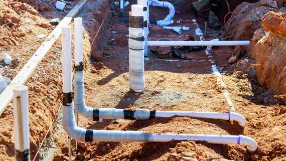 PVC pipes installed in a dirt trench at a construction site