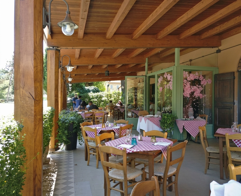 Terrazza esterna coperta del caffè con tavoli e sedie in legno e decorazioni floreali rosa.