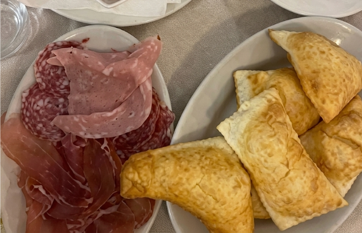 Piatti di salumi affettati e pasticcini ripieni su un tavolo