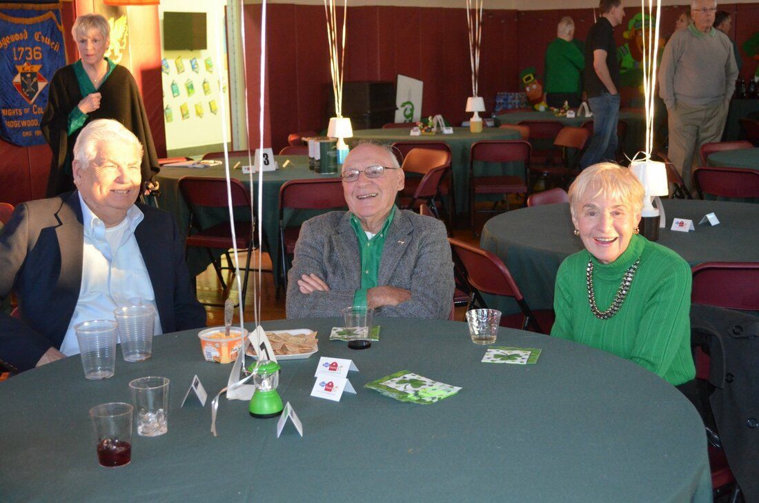A group of people are sitting around a table with cards on it
