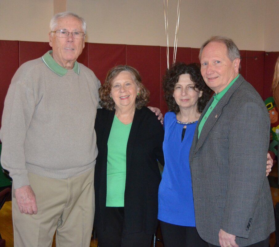 A group of people posing for a picture with one woman wearing a green shirt