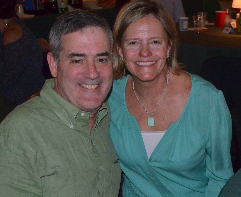 A man and a woman are posing for a picture and smiling