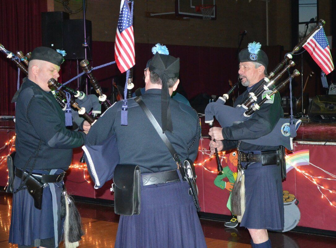 A group of men in kilts are playing bagpipes