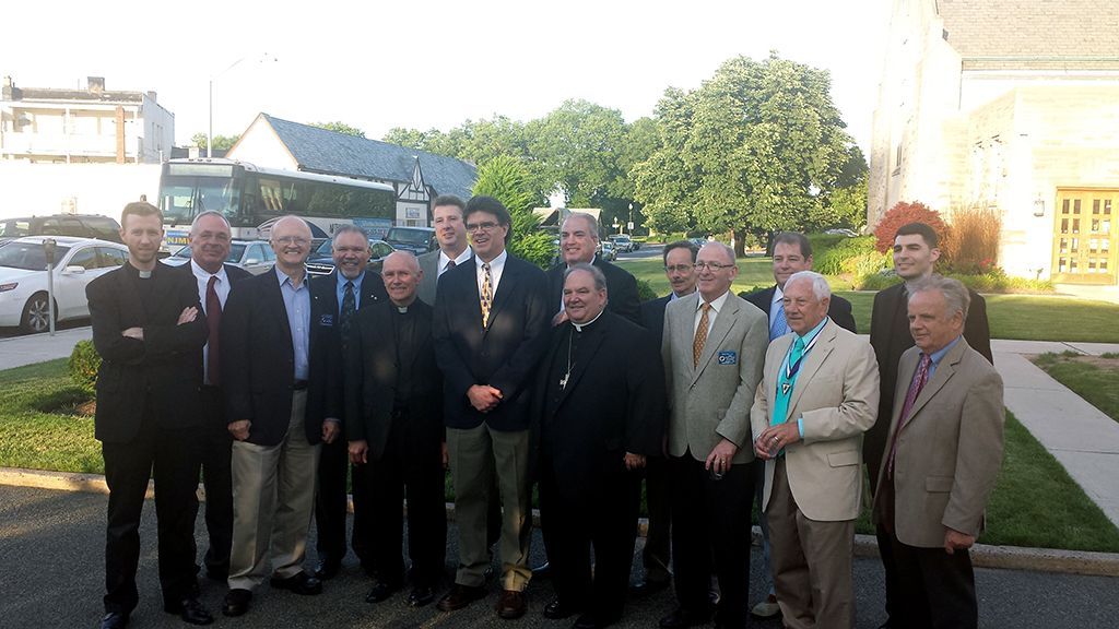 A group of men are posing for a picture in front of a church.