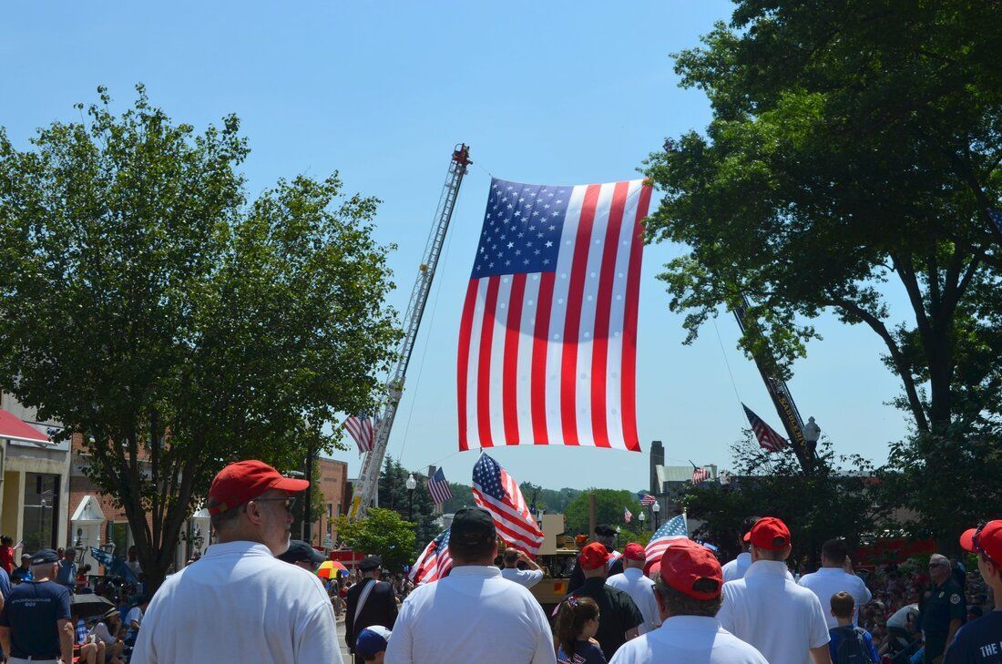 A group of people holding american flags in a parade