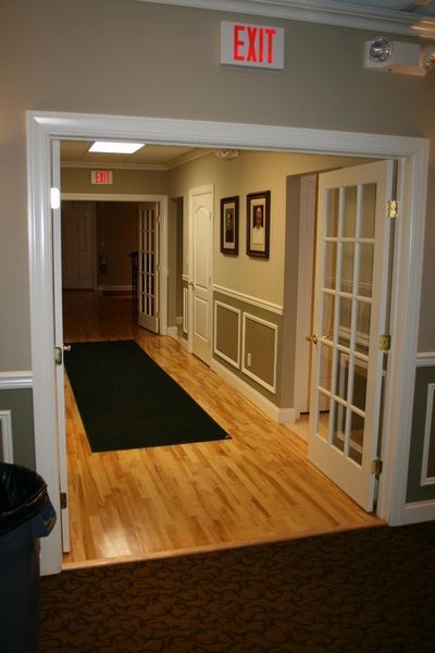 A hallway with a red exit sign on the wall
