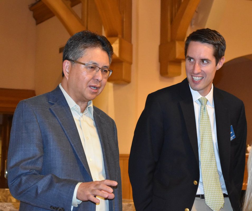Two men in suits and ties are standing next to each other