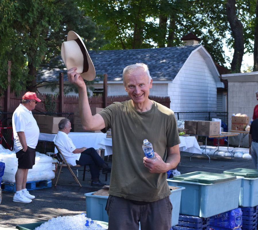 A man holding a cowboy hat and a bottle of water