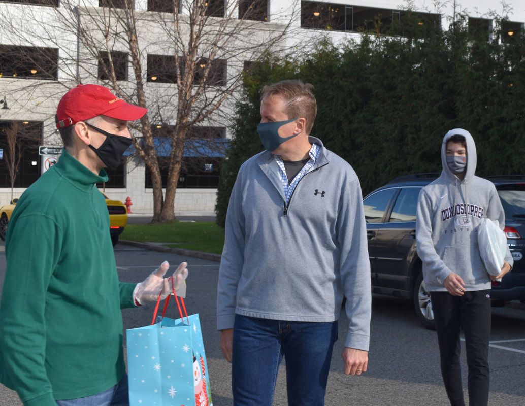 Three men wearing face masks are walking down a street