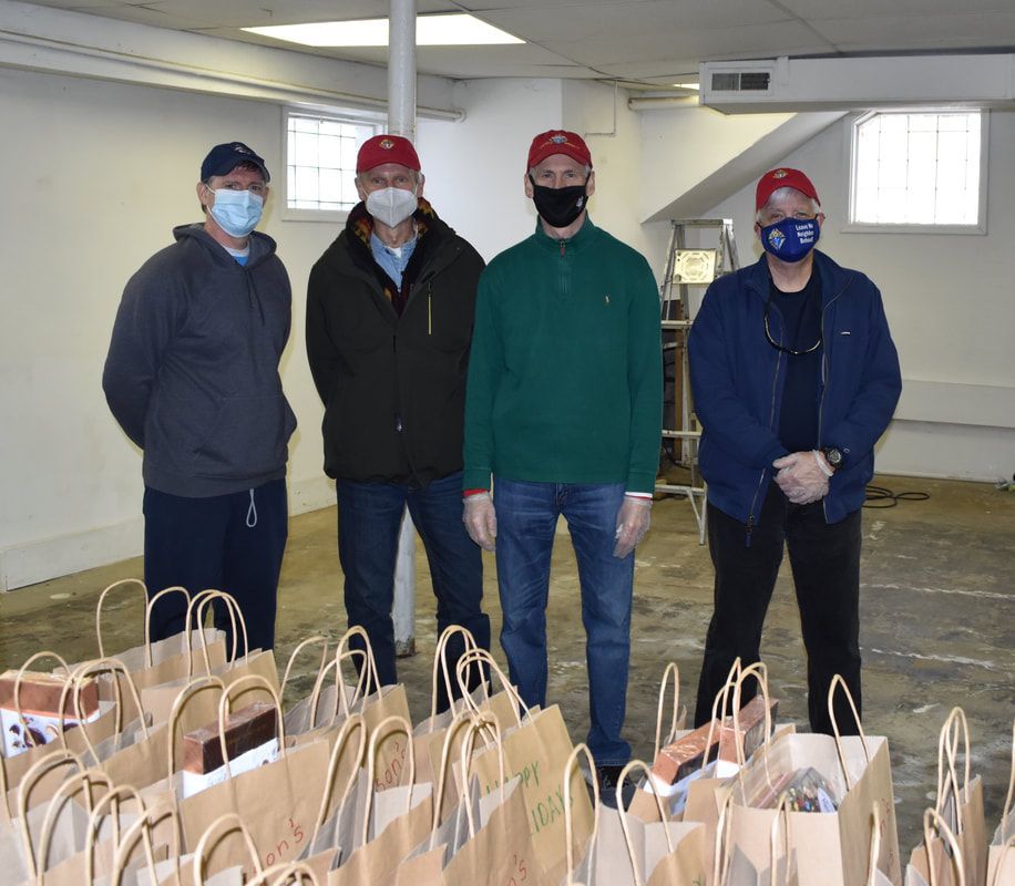 A group of men wearing face masks are standing in front of bags