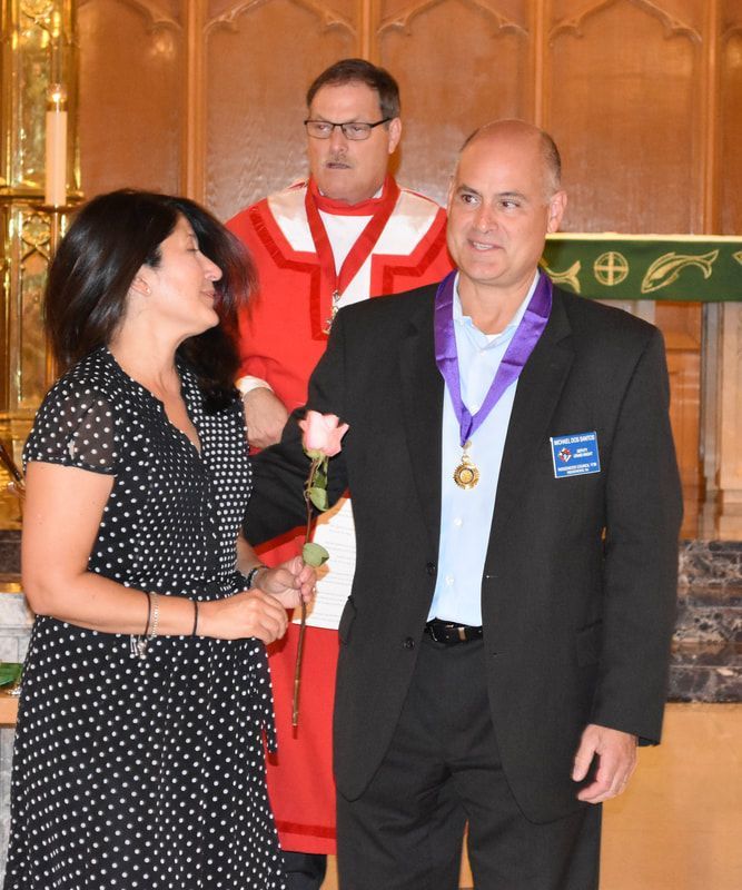 A man with a medal around his neck stands next to a woman
