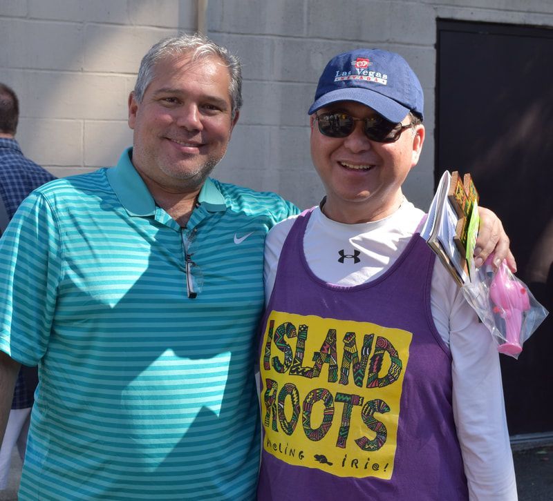 A man wearing a purple tank top that says island roots