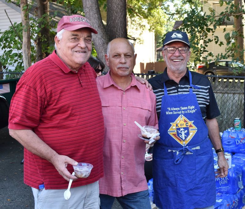 Three men posing for a picture with one wearing an apron that says ccl