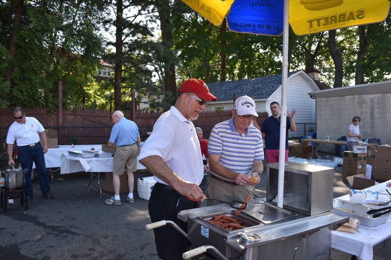 A man in a red hat is preparing food under an umbrella that says tt3ba2
