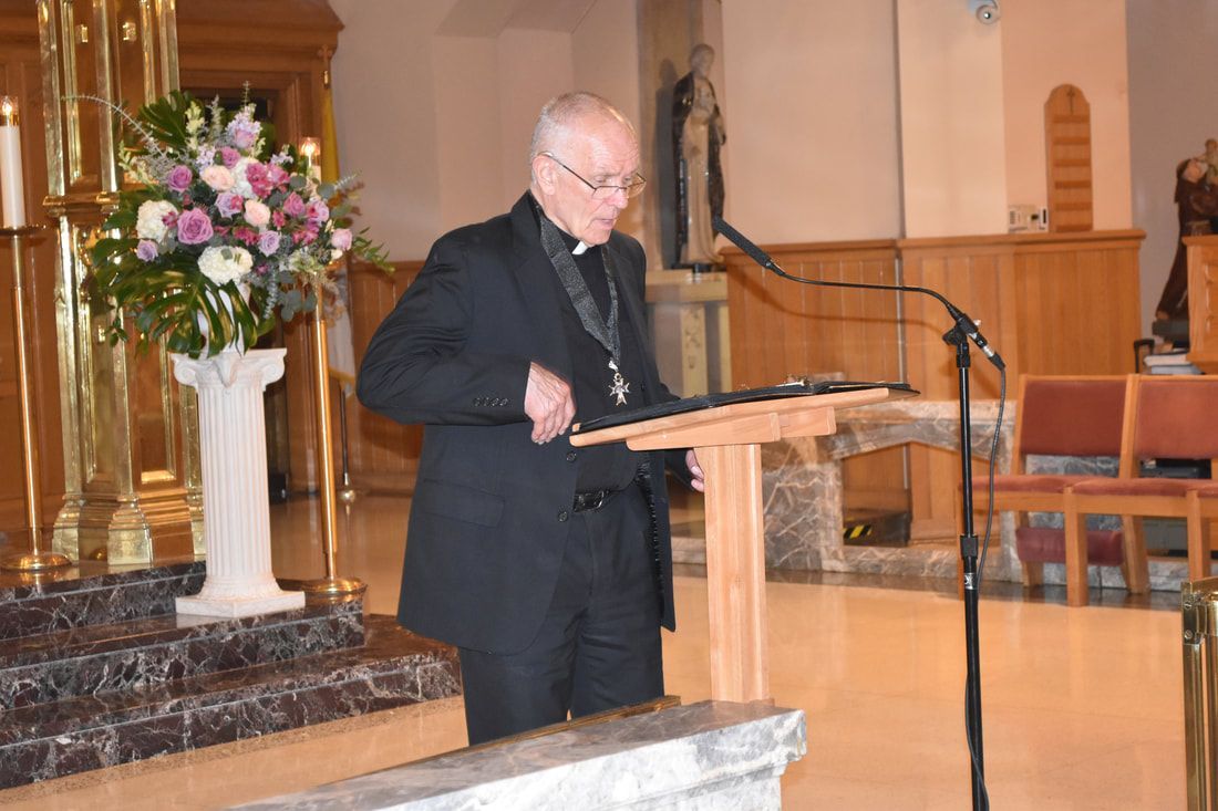 A man in a suit is standing at a podium in a church.
