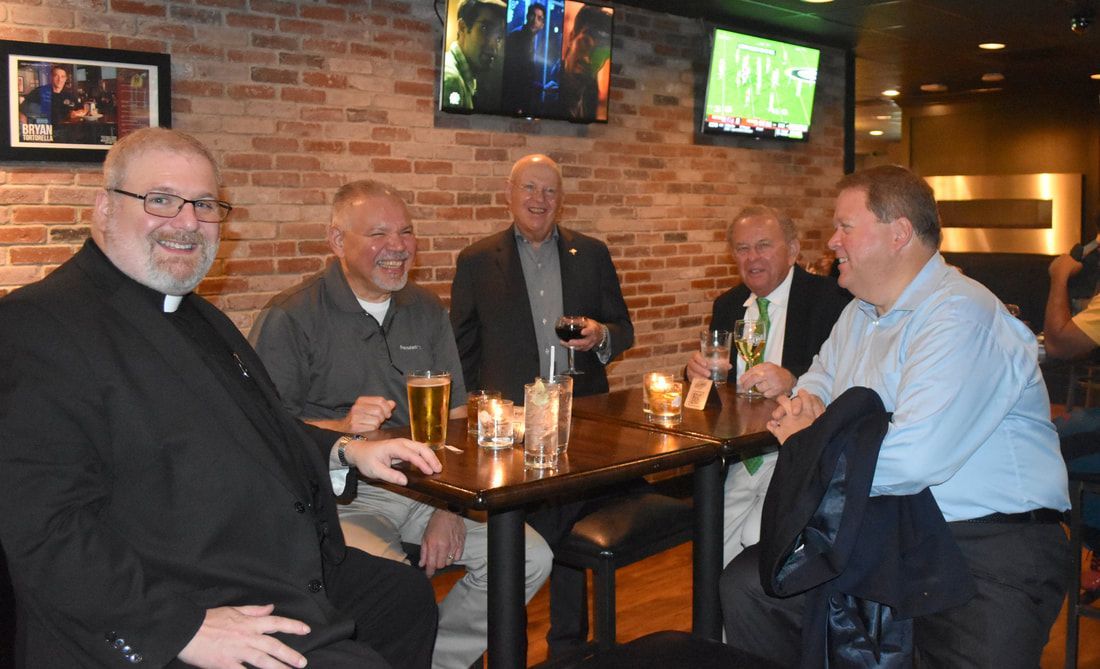 A group of men are sitting at a table in a restaurant.