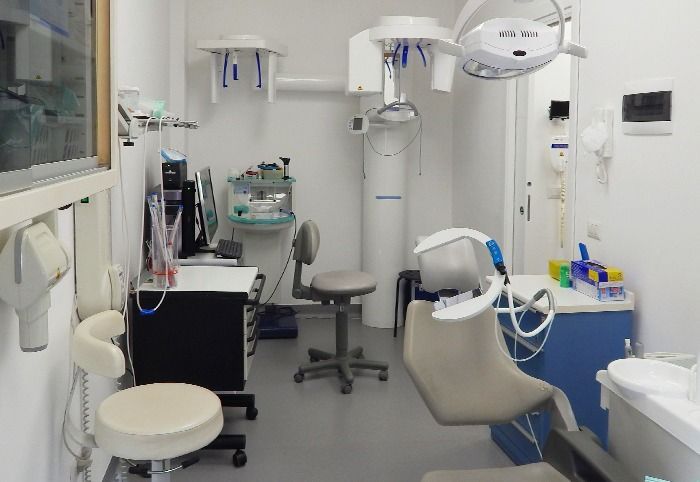 Ambulatorio odontoiatrico con poltrona, strumenti, lampada scialitica e zona lavabo