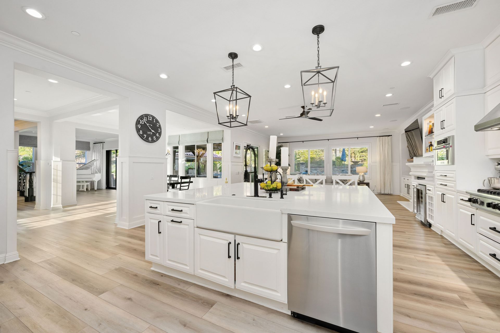 Bright white modern kitchen remodel with island, pendant lighting, and stainless appliances.
