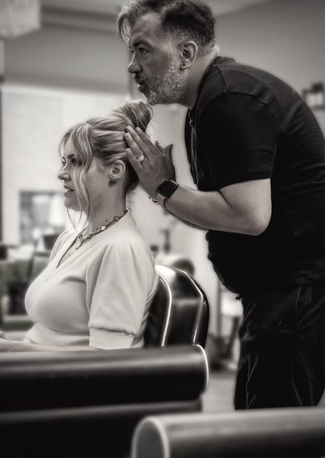 Gabe Ropi is blow drying a woman 's hair in a salon