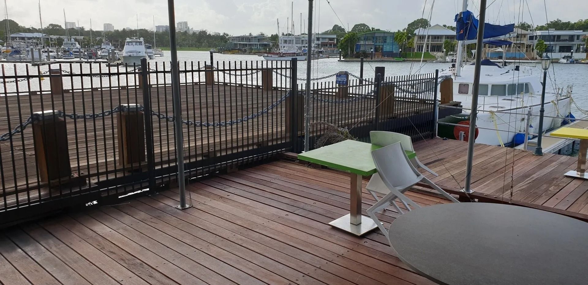 A Wooden Deck With a Table and Chairs and a Fence Surrounding It — Fence Factory In Berrimah, NT