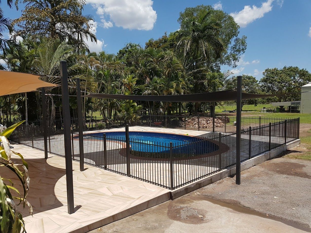A Black Metal Fence Surrounds a Pool — Fence Factory In Berrimah, NT