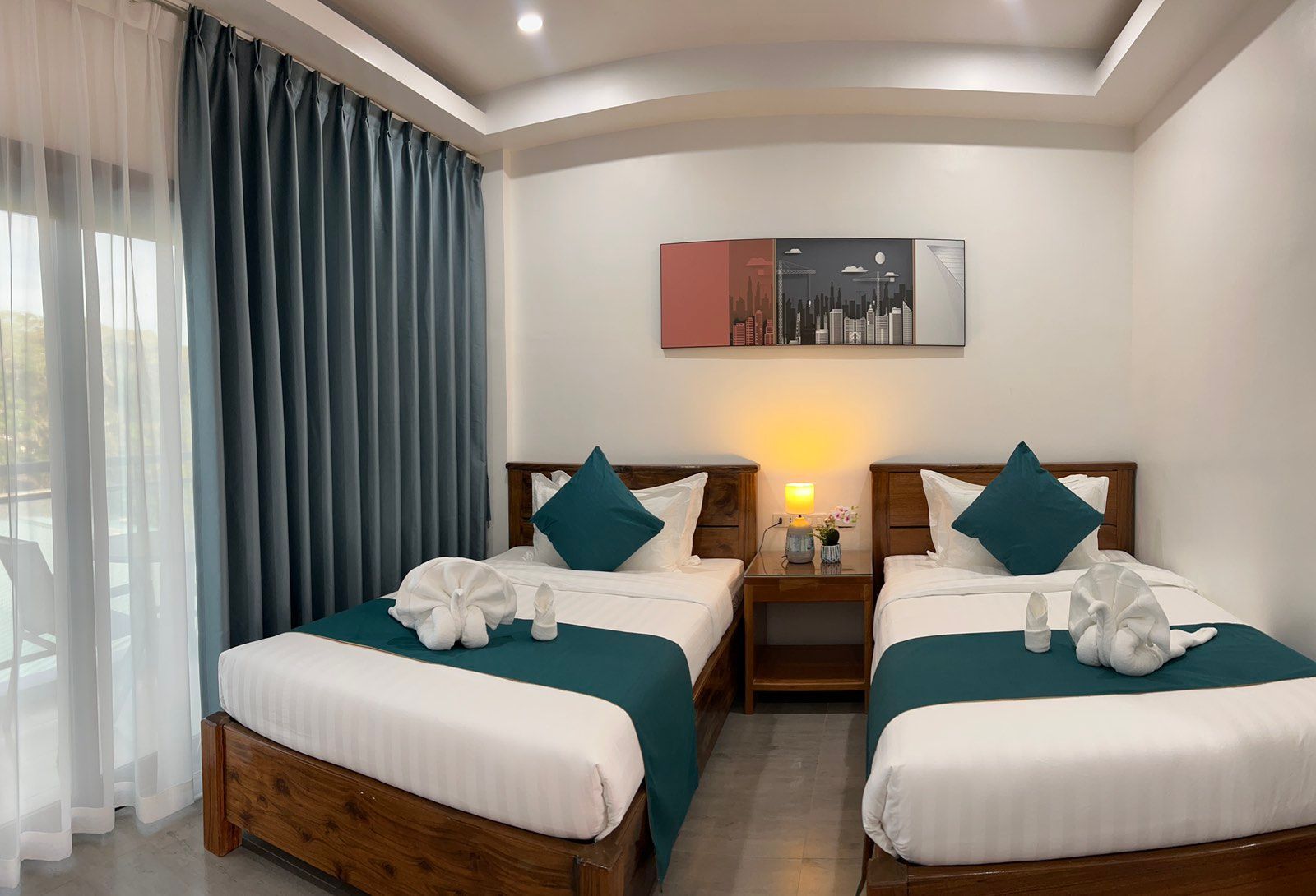A hotel room with two beds and a window.