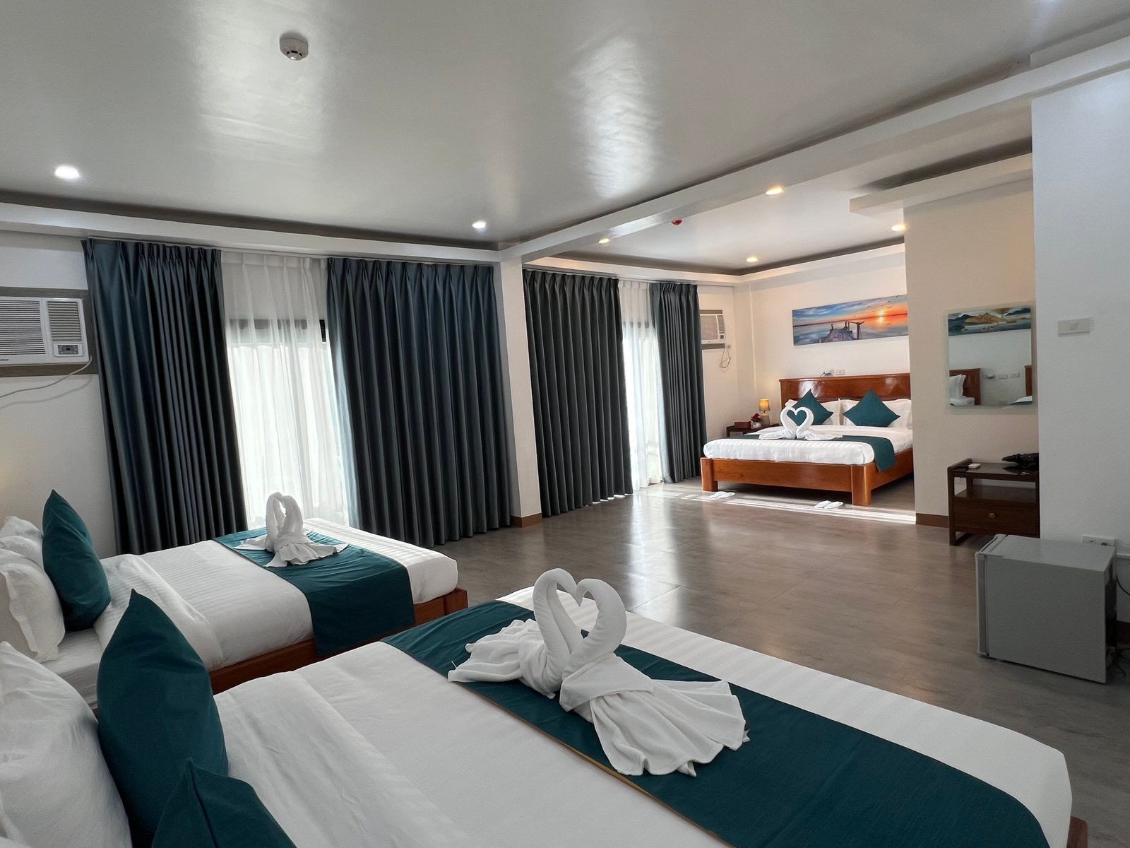 A hotel room with two beds and a large window