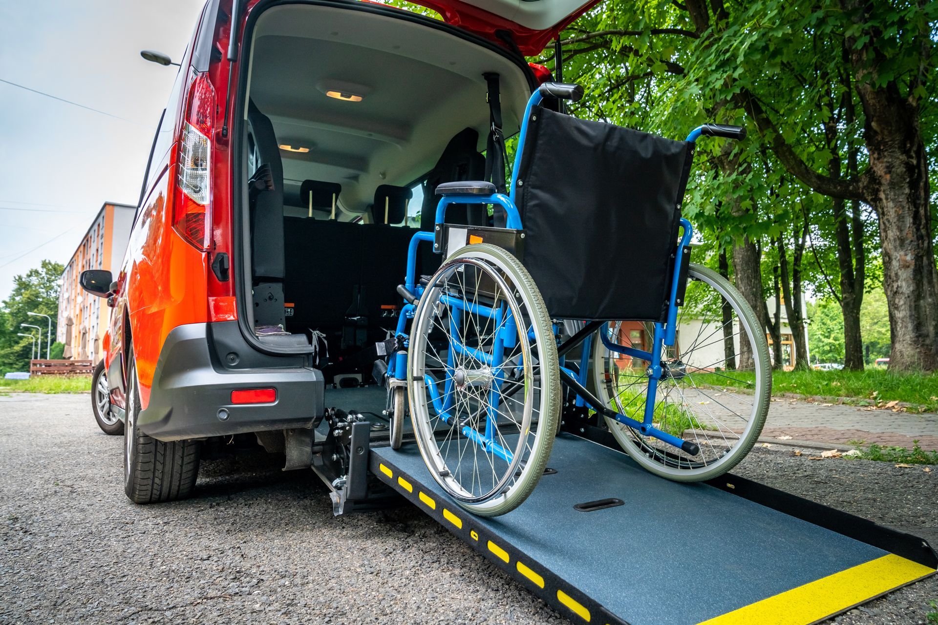 A wheelchair is being lifted into the back of a van
