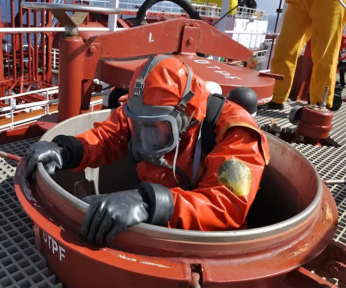 Person in Orange Hazmat Suit Entering a Red Tank on a Ship Deck — SDA Plumbing in Alice Springs, NT