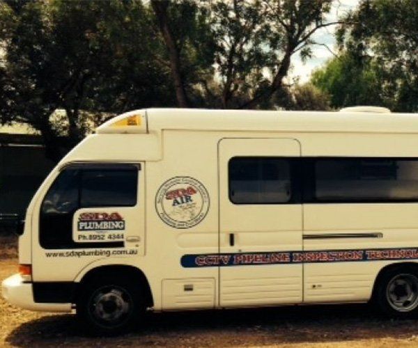 White plumbing company van with business logo parked outdoors. — SDA Plumbing in Alice Springs, NT