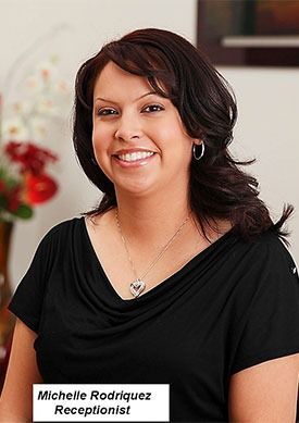 Portrait of Michelle Rodriguez, a smiling woman in a black top with a name tag.