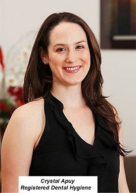 Portrait of Crystal Apuy in a black sleeveless top, smiling against a neutral indoor background