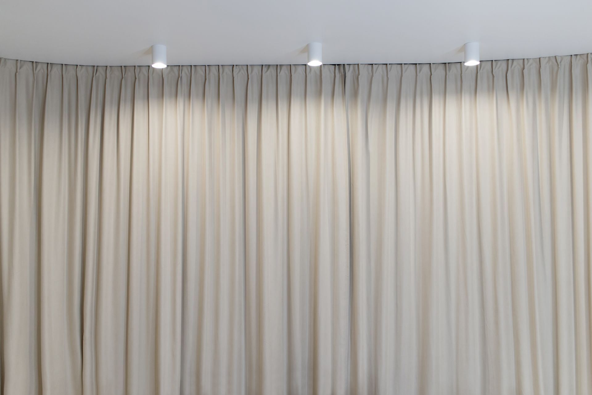 There are three lights hanging from the ceiling above the curtains.