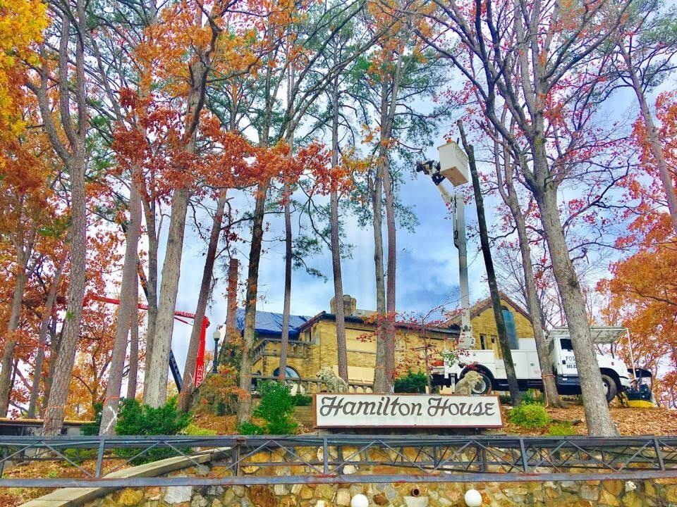 Hamilton House sign amid autumn trees with yellow house in the background
