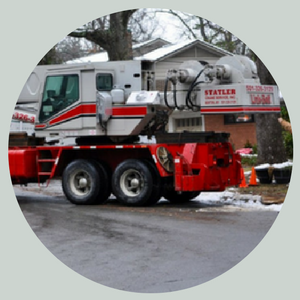 Red-and-white utility truck parked on a snowy street in front of houses