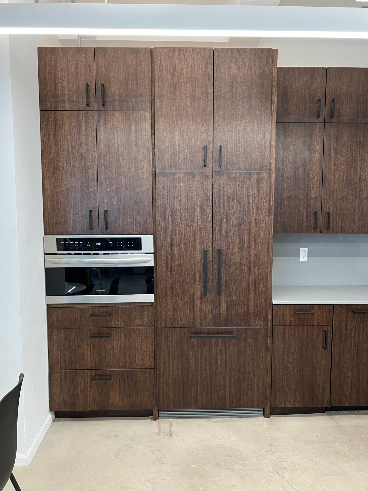 Dark wood kitchen cabinets with built-in appliances.