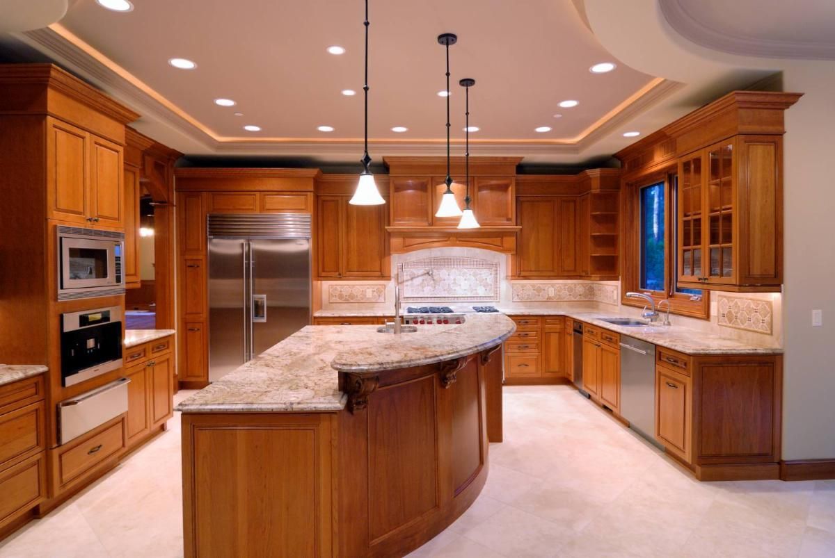 Kitchen with wood cabinets, granite countertops, stainless steel appliances, and recessed and pendant lighting.