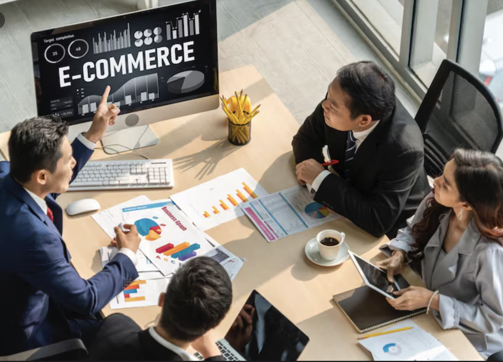 Business team meeting around e-commerce presentation on a screen