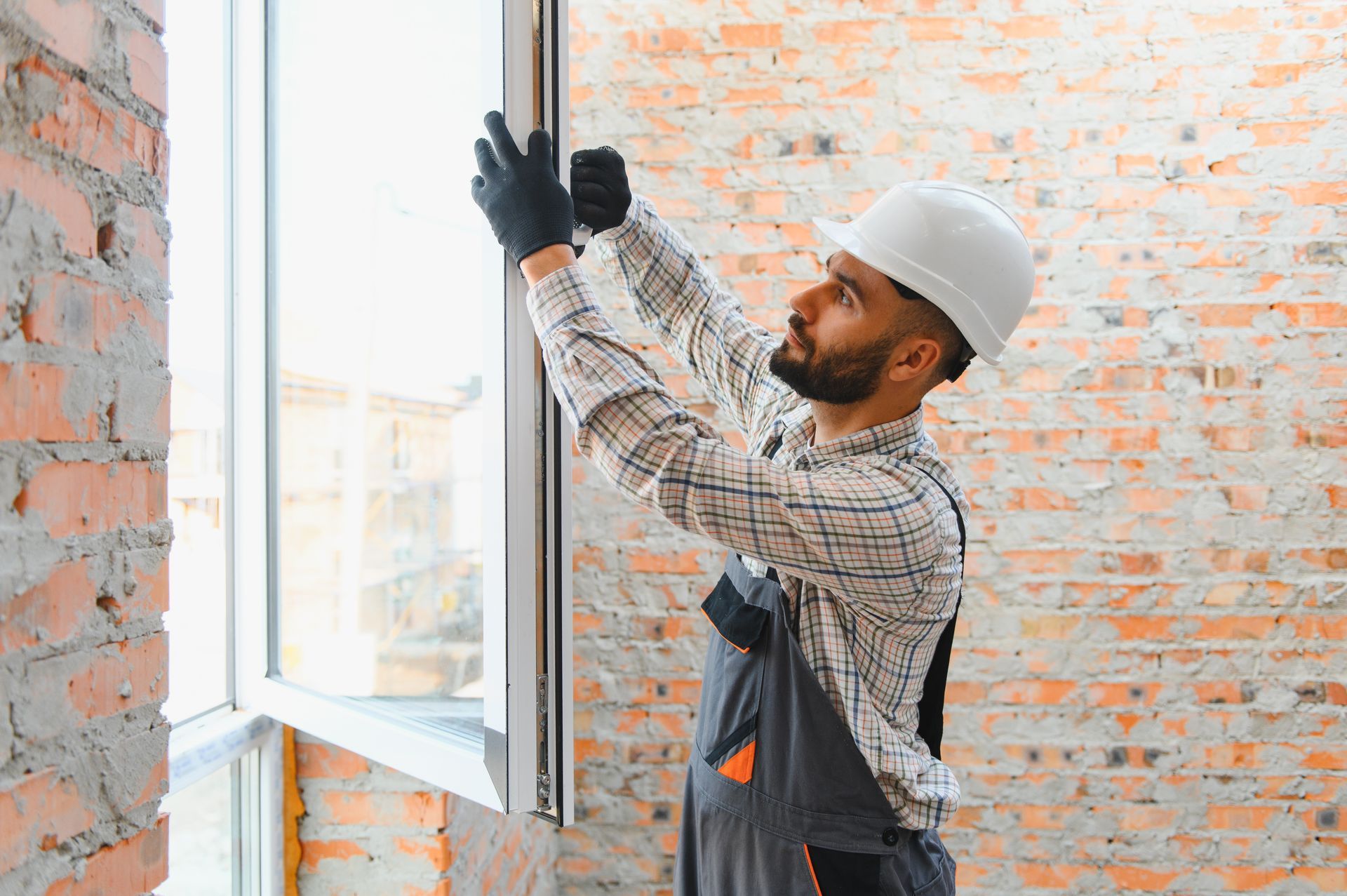 Worker installing a window in new construction commercial building