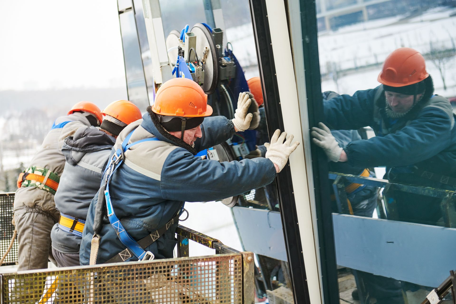 Workers installing a window pane in a commercial building