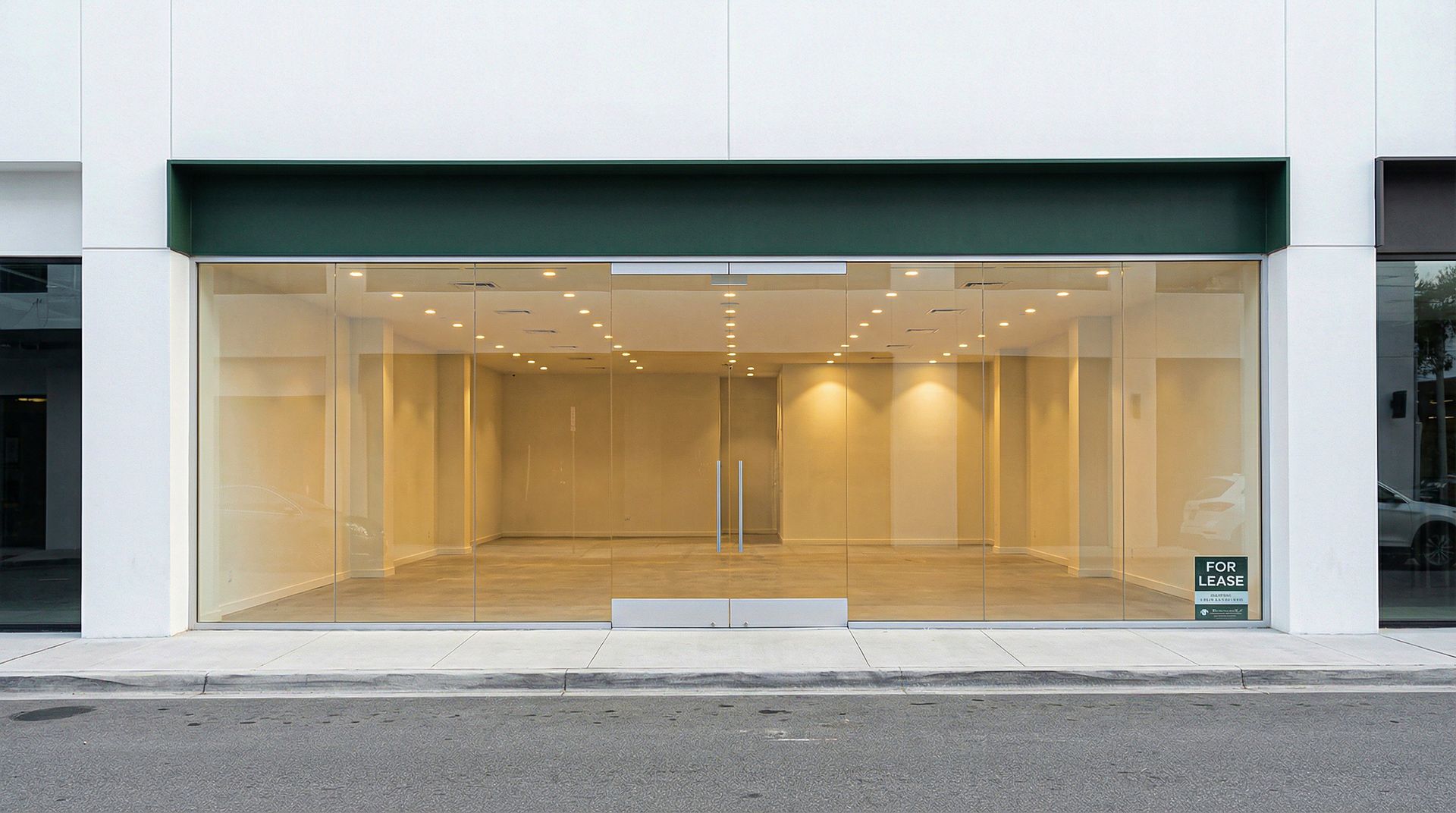 Vacant commercial glass storefront with For Lease sign in window.