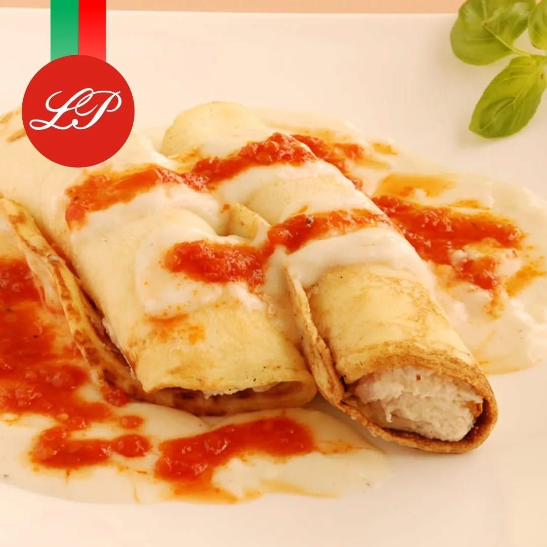 Canelones con salsa de tomate, en plato blanco.