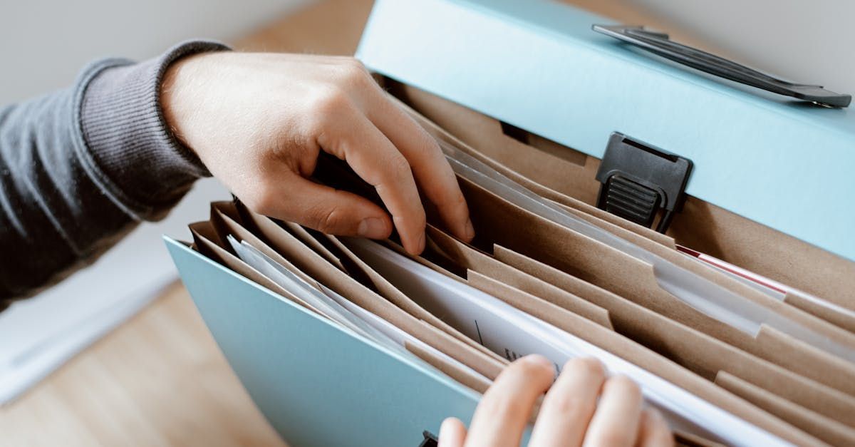 A person is holding a folder with papers in it.
