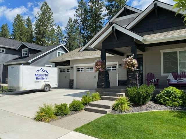 Suburban house with a moving trailer parked in the driveway and a well-kept front lawn