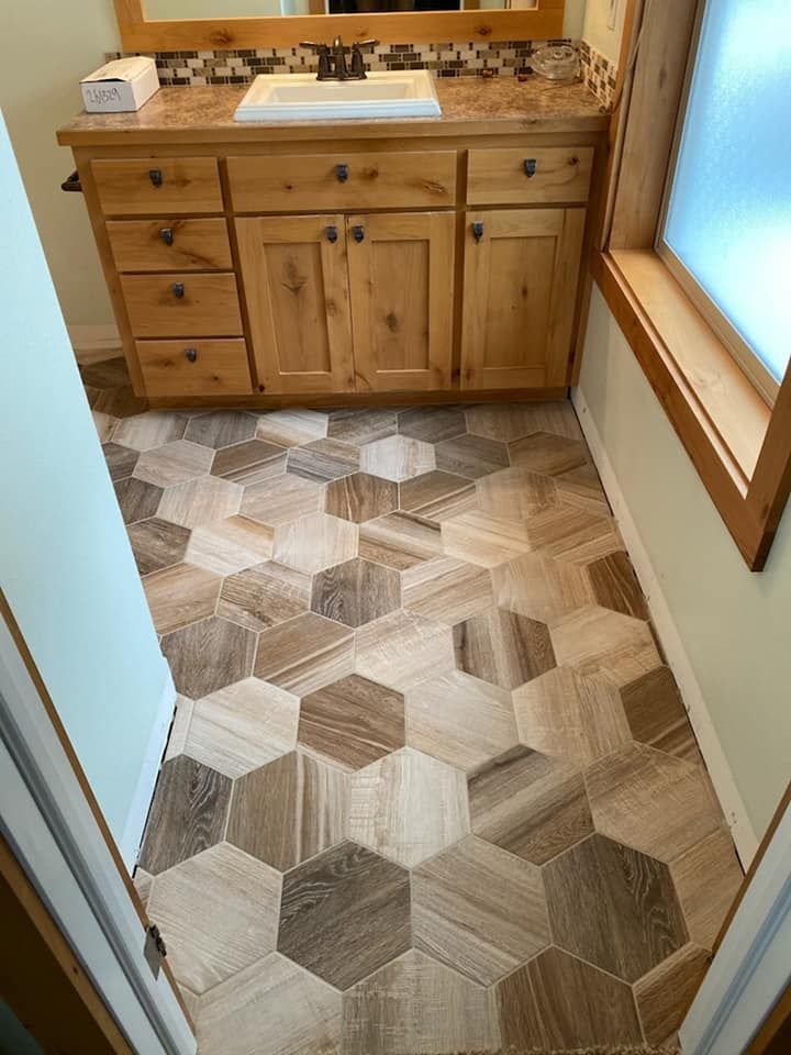 Small bathroom with a wooden vanity and geometric wood-pattern tile floor.