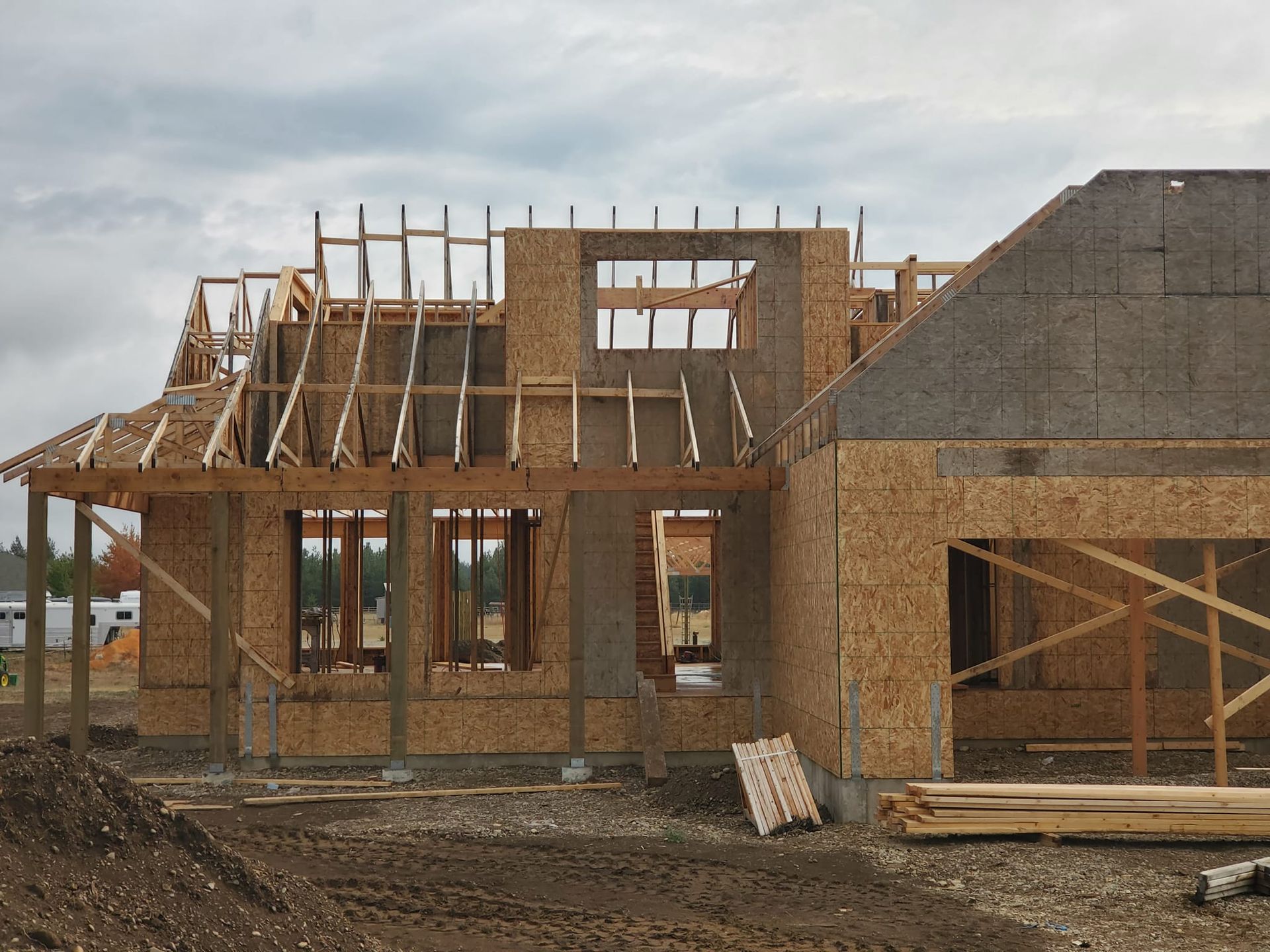 Partially framed house under construction with exposed wooden walls and roof trusses