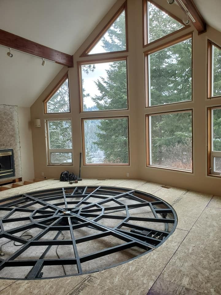 Unfinished living room with large windows and a circular sunken floor frame in the center