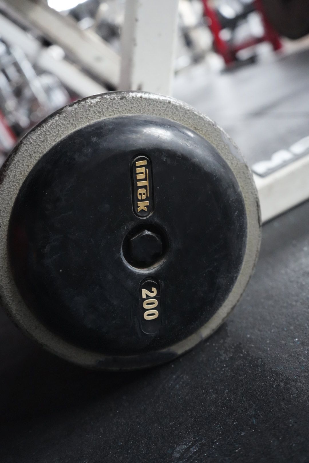 Close-up of a black round weight plate labeled 20.