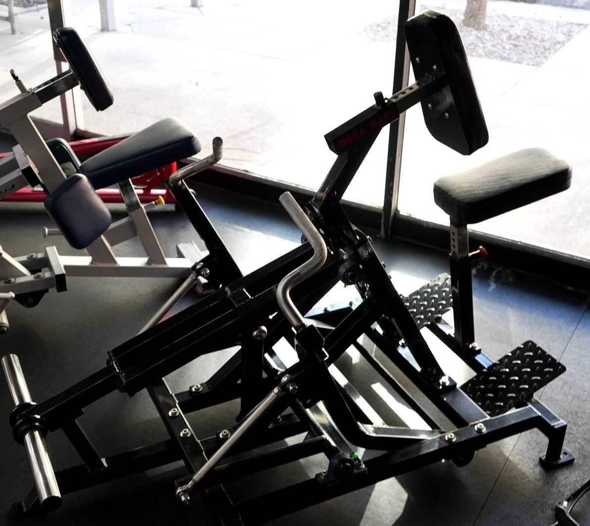 Gym weight machines by a large window in a fitness room
