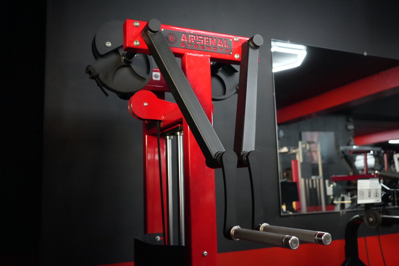 Red and black weight machine with a padded seat in a gym